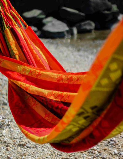 Le hamac artisanal Kaju est typique de la Colombie. Avec ses couleurs chaudes comme le rouge, le jaune ou le orange. Il possède des motifs indigènes tissés entièrement à la main.